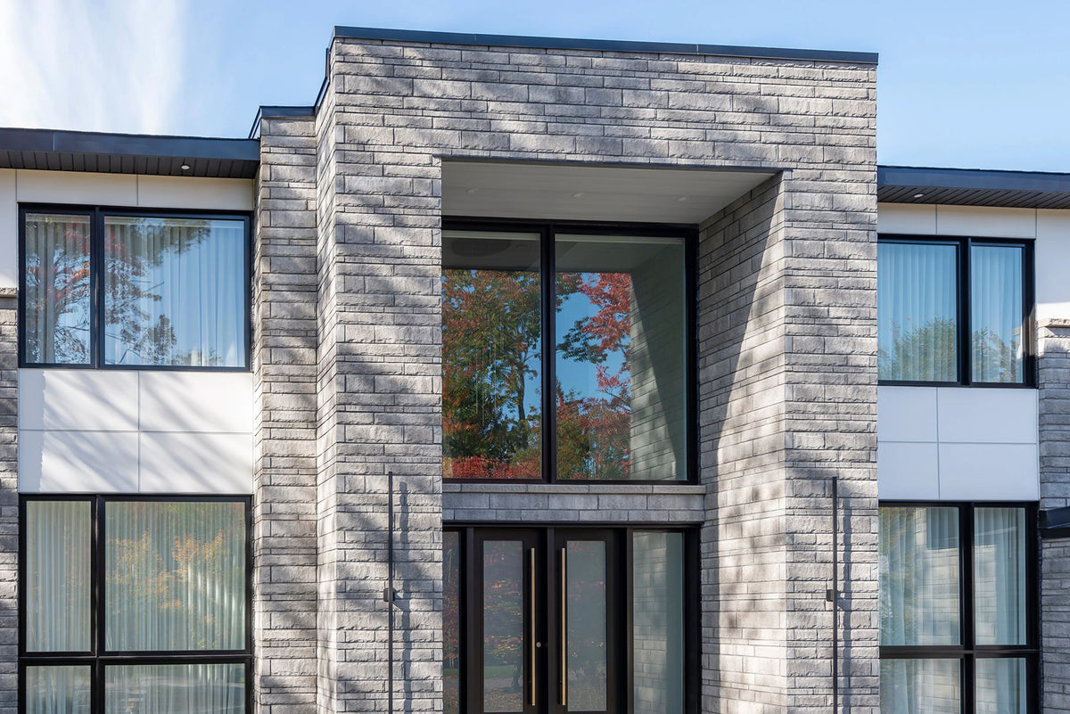 Pierre de béton grise avec texture légèrement ciselée, idéale pour revêtement de façade.