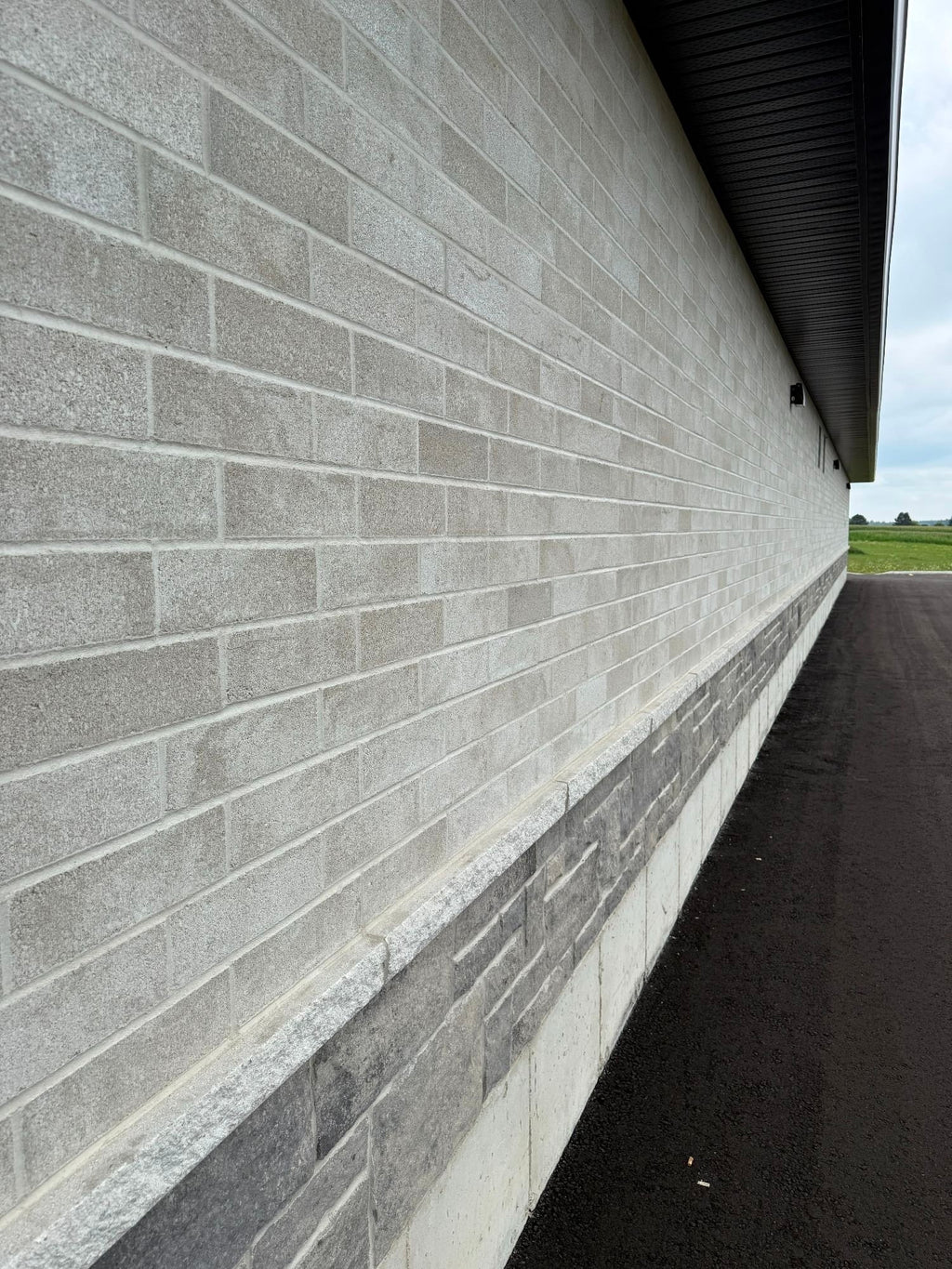 Mur de briques en béton gris, avec une texture lisse et des joints uniformes.