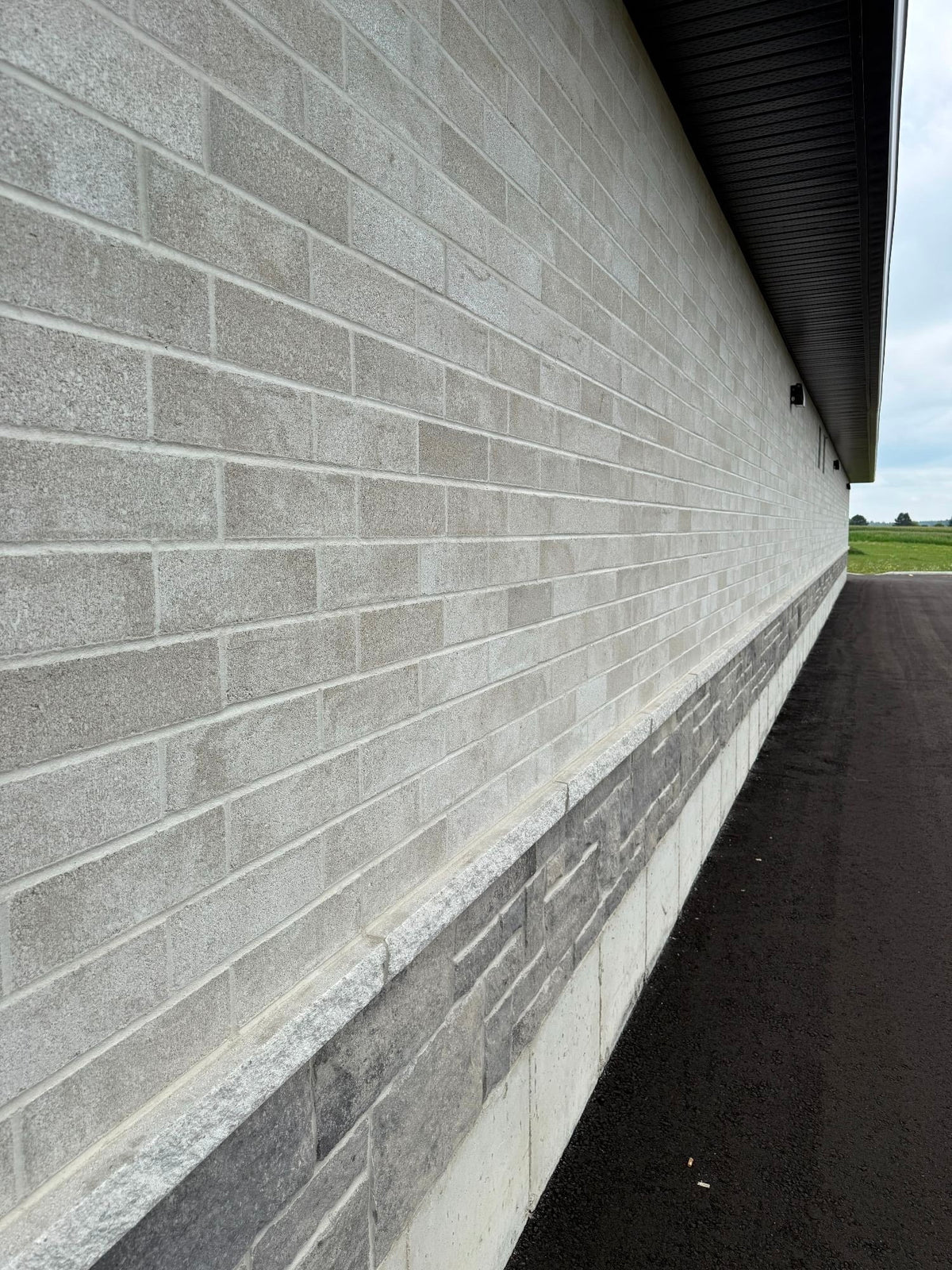 Mur de briques en béton gris, avec une texture lisse et des joints uniformes.