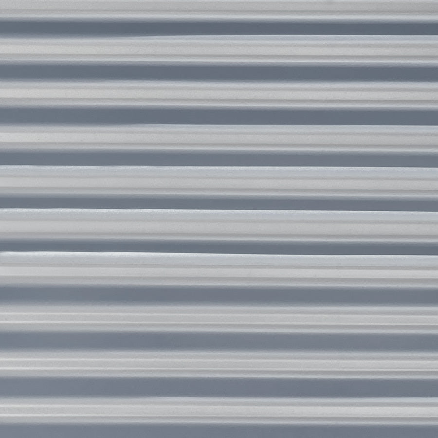 Panneau en métal ondulé de couleur gris clair avec des lignes horizontales régulières.