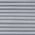 Panneau en métal ondulé de couleur gris clair avec des lignes horizontales régulières.