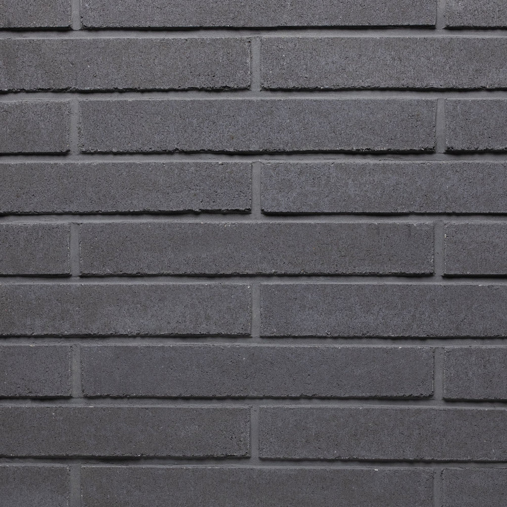 Mur en briques grises, avec une texture lisse et des joints bien définis, créant un motif uniforme.