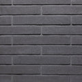 Mur en briques grises, avec une texture lisse et des joints bien définis, créant un motif uniforme.