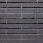 Mur en briques grises, avec une texture lisse et des joints bien définis, créant un motif uniforme.