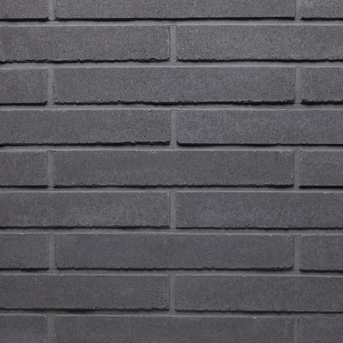 Mur en briques grises, avec une texture lisse et des joints bien définis, créant un motif uniforme.