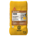Mortier de réparation SikaQuick 1000, sac jaune de 25 kg, avec avertissement de danger, pour durcissement rapide.