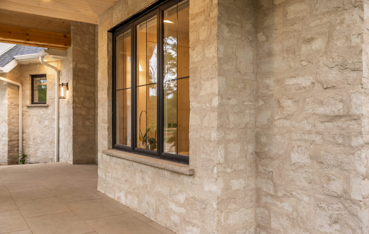 Mur en pierre beige texturée, évoquant la pierre taillée, avec nuances naturelles.