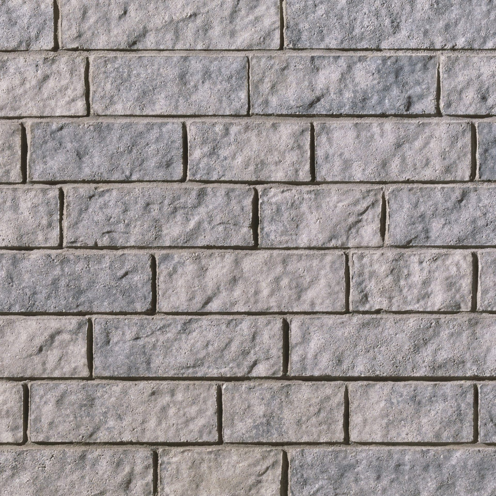Mur en briques grises avec une texture rugueuse, disposées en rangées régulières.