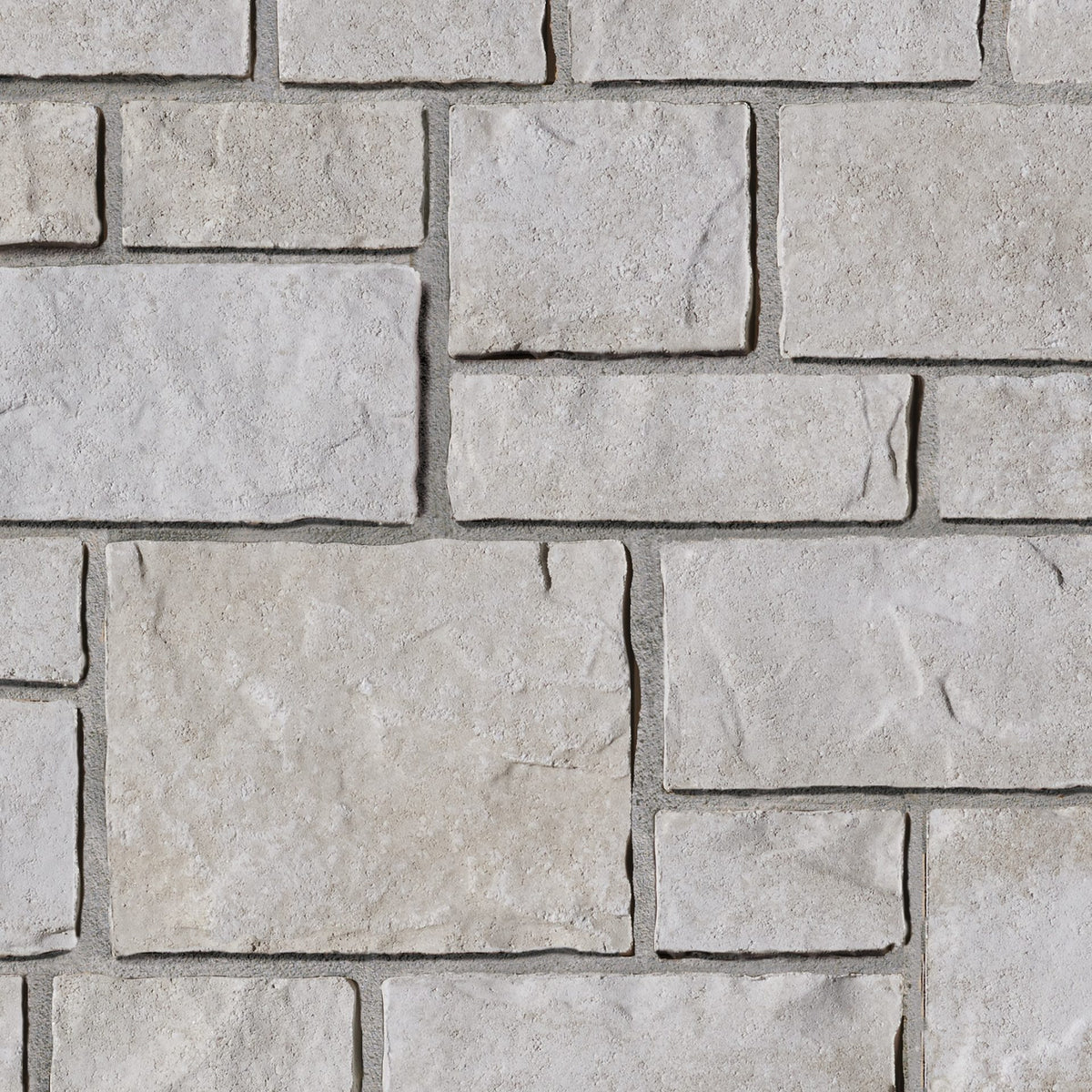 Mur en pierre de couleur beige clair avec des blocs de différentes tailles et textures, créant un motif naturel.