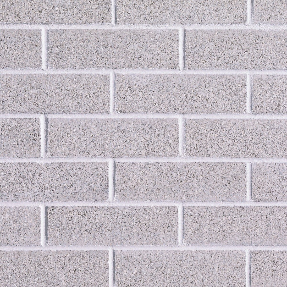 Mur de briques grises avec une texture lisse, disposées en rangées régulières.