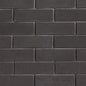 Briques noires en béton disposées en motif de maçonnerie, surface lisse et uniforme.