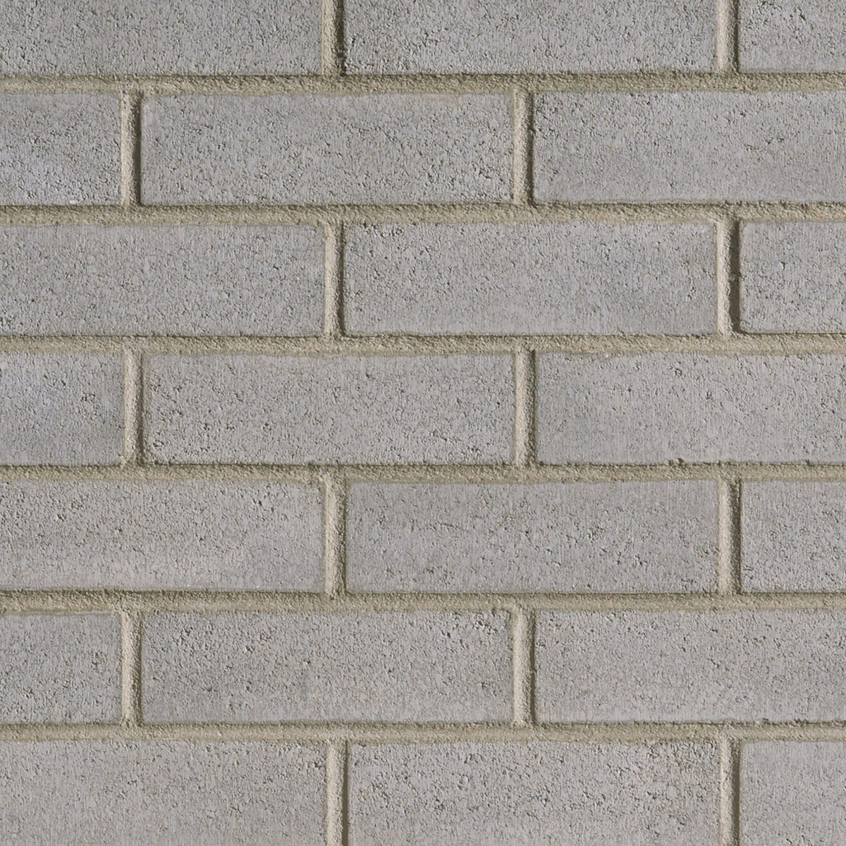 Mur de briques en béton gris, avec des joints visibles entre les briques, texture rugueuse et uniforme.