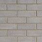 Mur de briques en béton gris, avec des joints visibles entre les briques, texture rugueuse et uniforme.