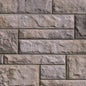 Mur en briques grises avec texture rugueuse, disposées de manière uniforme, créant un motif de maçonnerie.