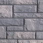 Mur de briques en béton gris, avec une texture rugueuse et des joints visibles, disposé en motif rectangulaire.