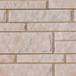 Mur en briques beige avec des textures et des joints visibles, créant un aspect de maçonnerie.